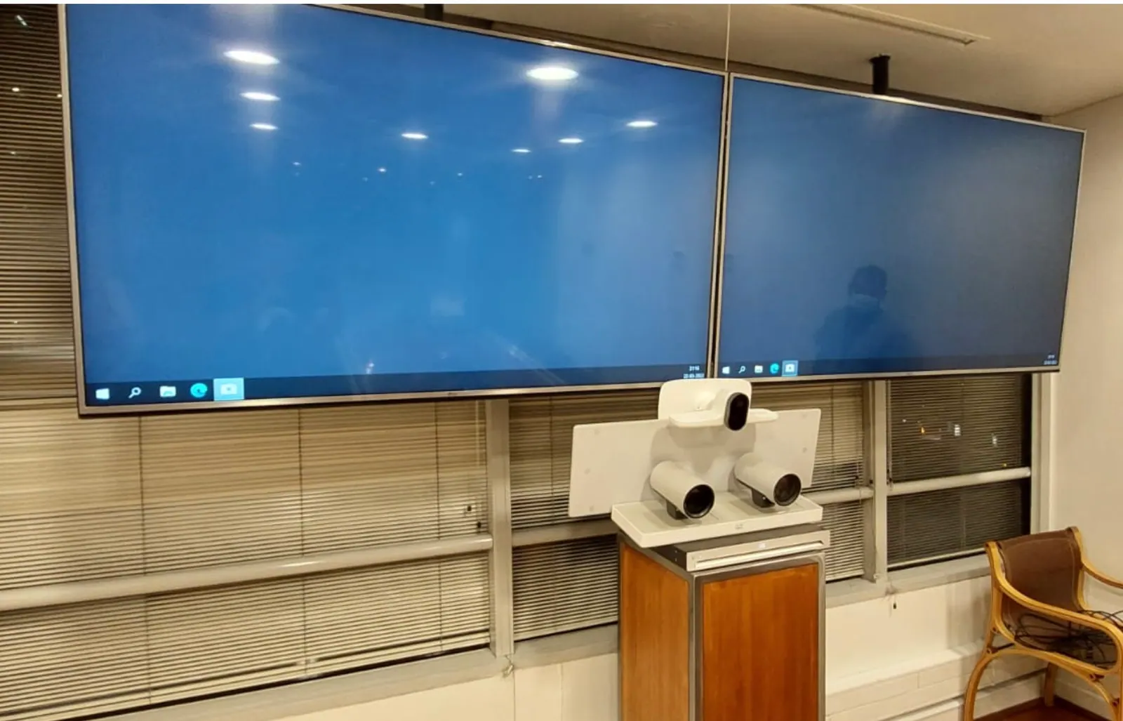 Sala corporativa con doble pantalla, cámara PTZ y sistema de videoconferencia