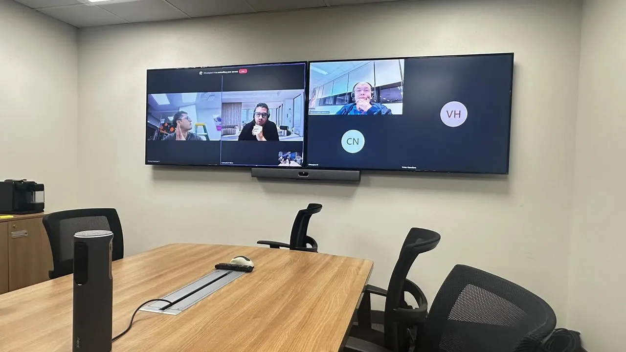 Sala hibrida con doble pantalla y barra de videoconferencia para reuniones rapidas